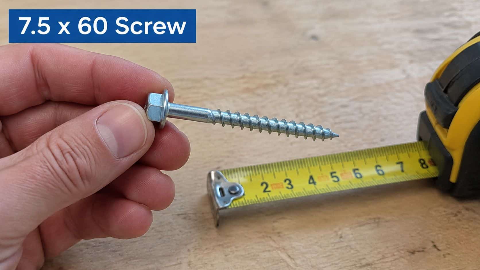 A person holding a 7.5 x 60 mm hex head screw next to a tape measure for scale.